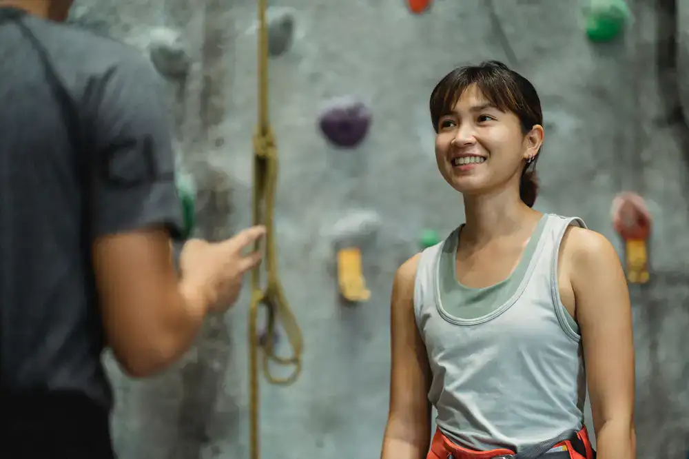 Instructor pointing at a specific hold while analyzing a route with a student