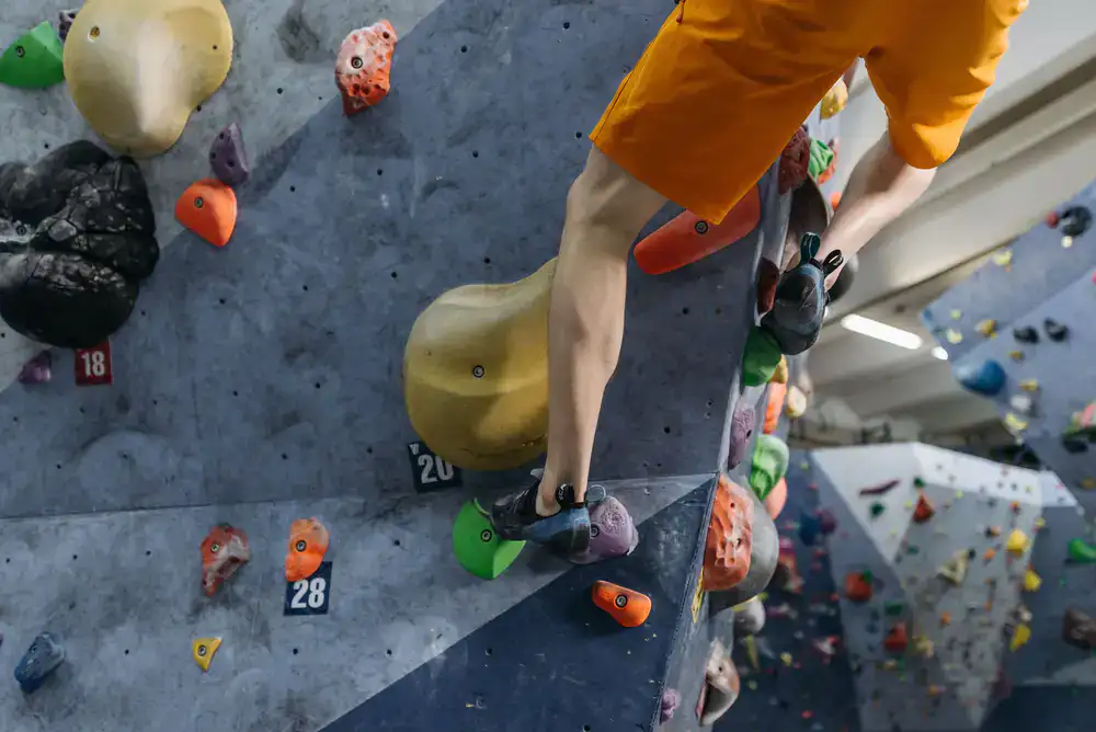 A route setter installing new holds on a steep bouldering wall